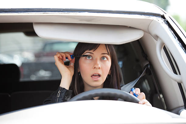 Woman putting make-up on while driving.